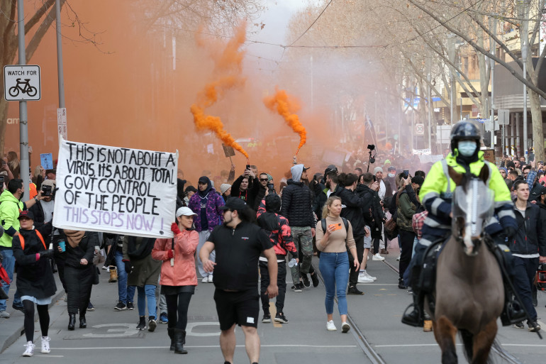 Protesters march down a street during a rally Melbourne on July 24, 2021 to demonstrate against the city's restrictions due to the Covid-19 coronavirus. (Photo by CON CHRONIS / AFP)