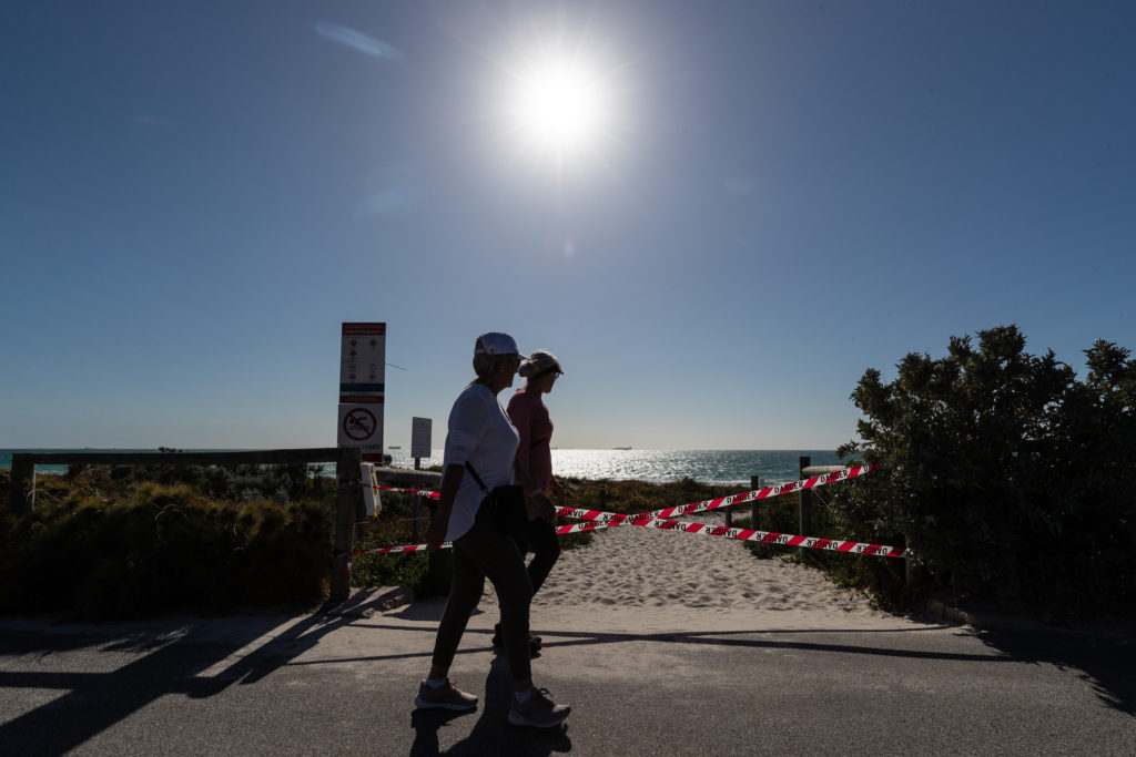 Members of the public walk past closed beach tape at Leighton Beach in North Fremantle, Western Australia, Saturday November 6. 2021. Beaches have been closed amid fears of a shark attack near Perth, with a man reported missing. (AAP Image/Richard Wainwright) NO ARCHIVING