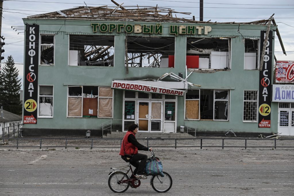TOPSHOT - A woman rides a bike past a destroyed building in Balakliya, Kharkiv region, on September 10 , 2022. - Ukrainian forces said September 10, 2022 they had entered the town of Kupiansk in eastern Ukraine, dislodging Russian troops from a key logistics hub in a lightning counter-offensive that has seen swathes of territory recaptured. (Photo by Juan BARRETO / AFP) (Photo by JUAN BARRETO/AFP via Getty Images)