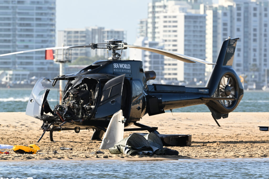 A damaged Sea World Helicopter at the scene of a helicopter collision near Seaworld, on the Gold Coast, Monday, January 2, 2023. Four people are dead and another 13 injured after two helicopters collided before one crashed into the Broadwater on the Gold Coast. (AAP Image/Dave Hunt) NO ARCHIVING