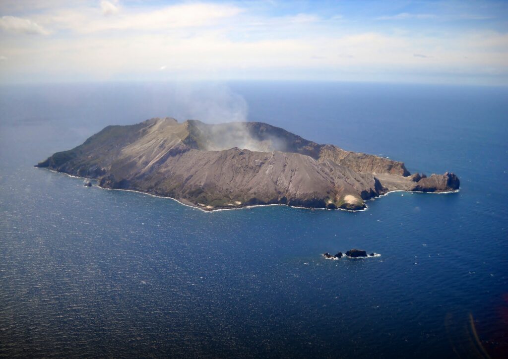 White Island from above, with some smoke appearing above the mouth of the marine volcano