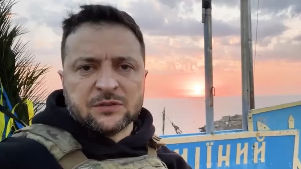 Volodymyr Zelensky in a video, with a sunset over Snake Island behind him