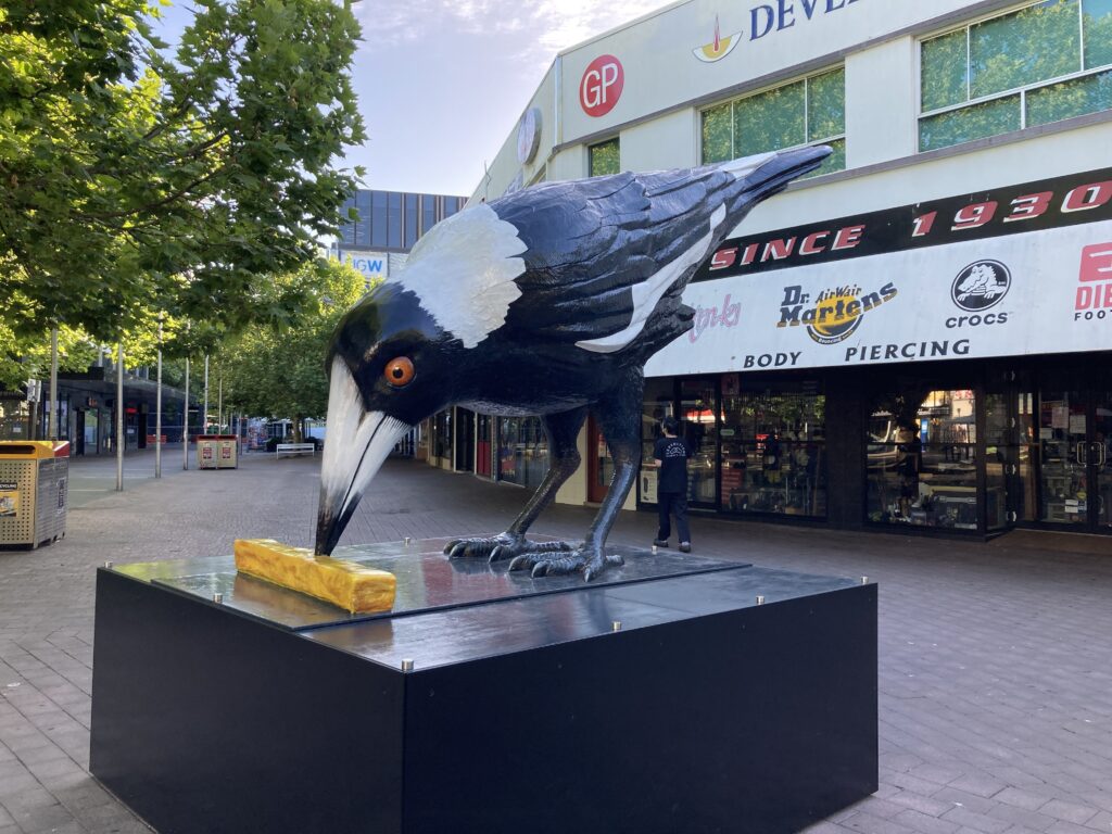 A statue of a magpie pecking a hot chip